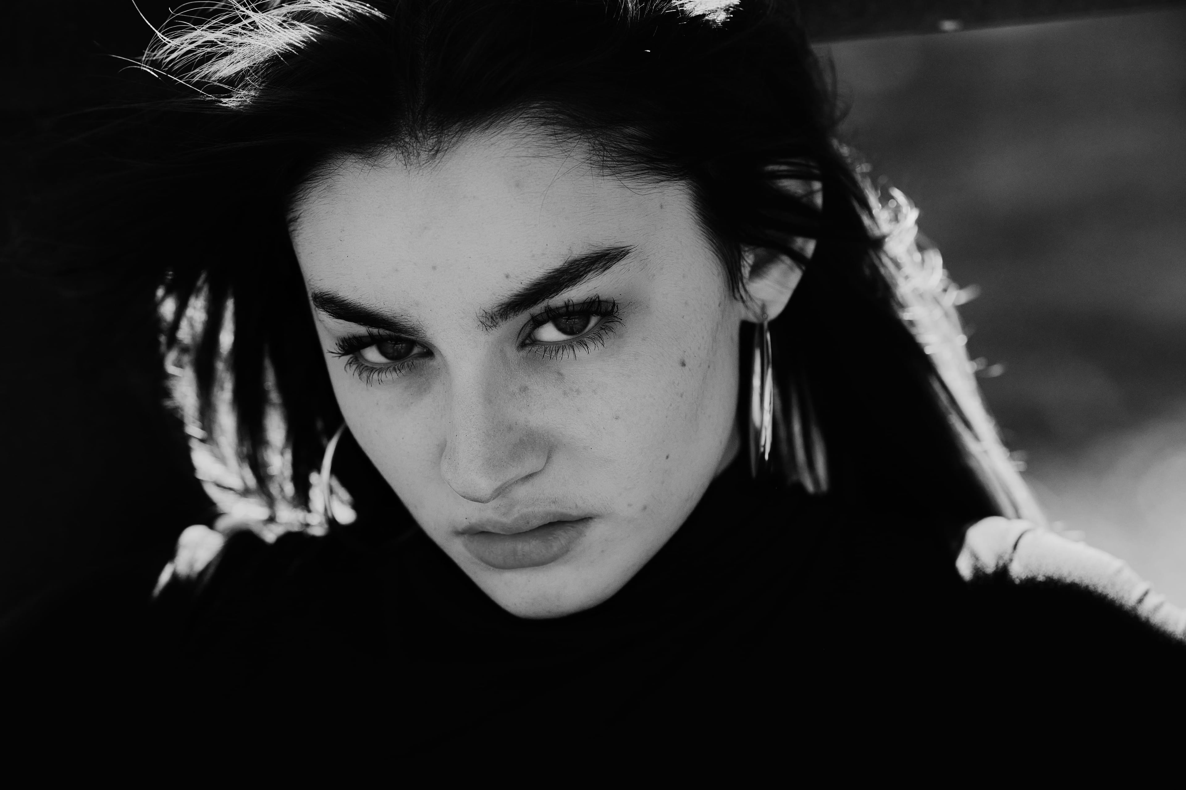 Mackenzie Pearson, close portrait in hard light, hair back, black and white